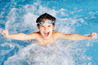a kid swimming in the pool.