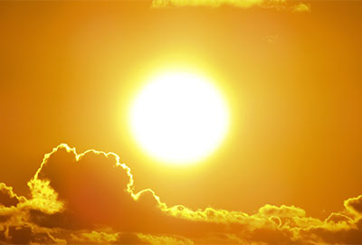 sun with clouds in yellow sky