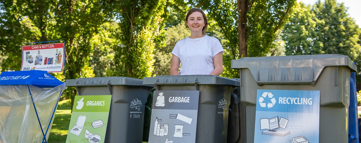 Female EcoSmart team member in front of a waste sorting station