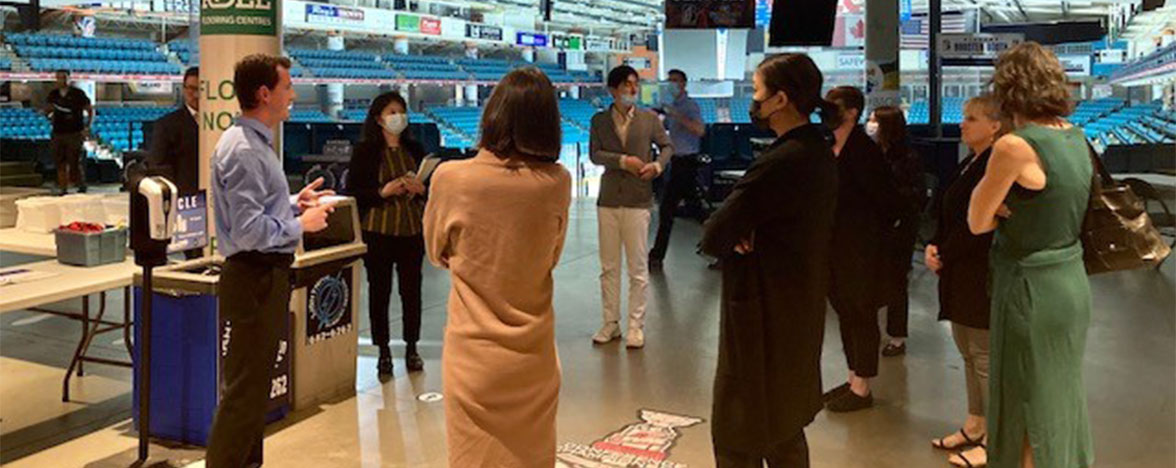 Group gathering listening to a City representative explain the Cooling Centre building layout