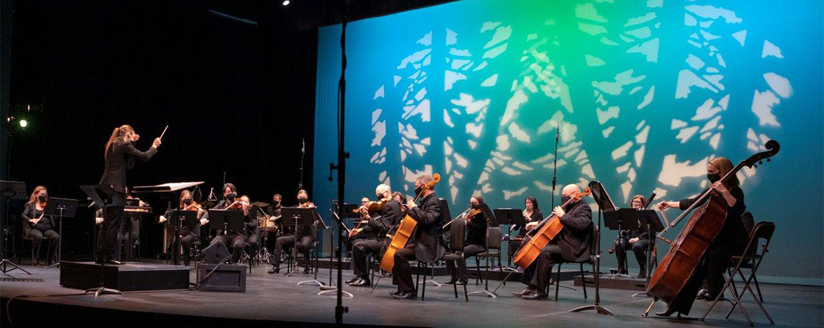 Kamloops Symphony on stage with colorful tree backdrop