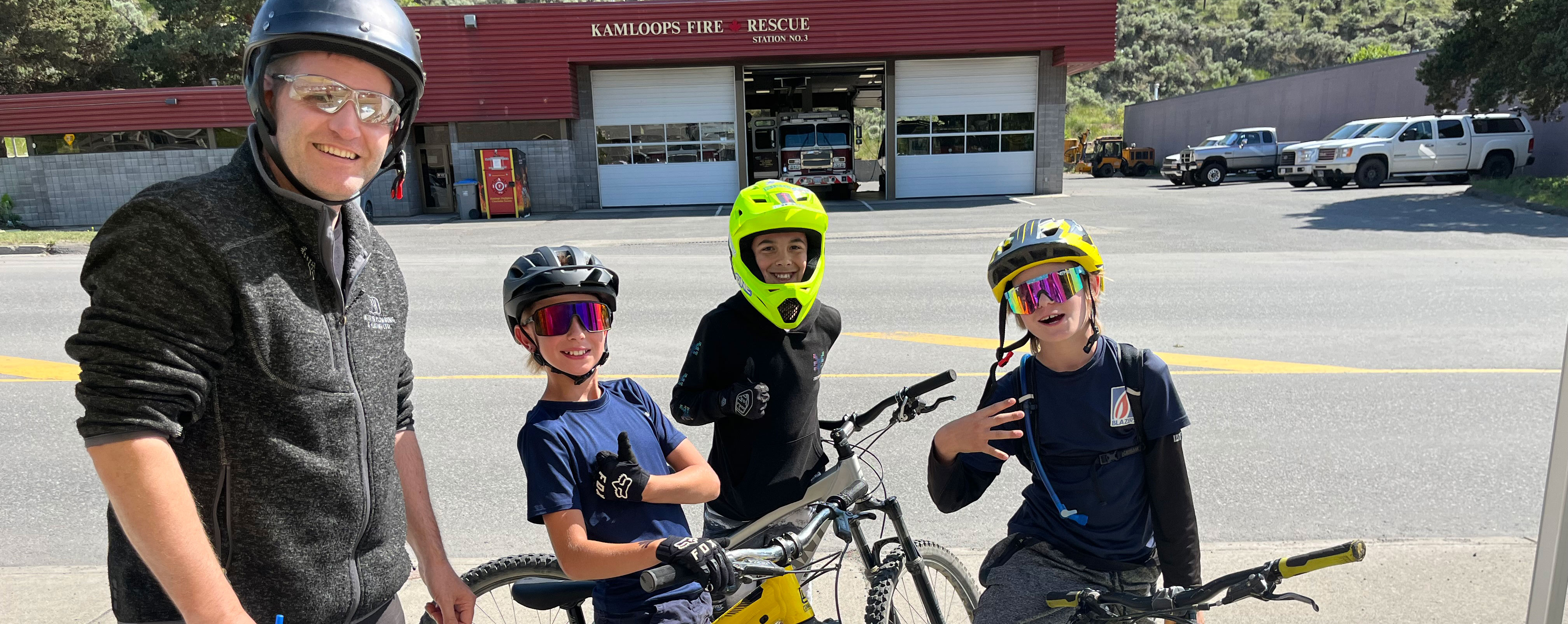 Three children and an adult with helmets