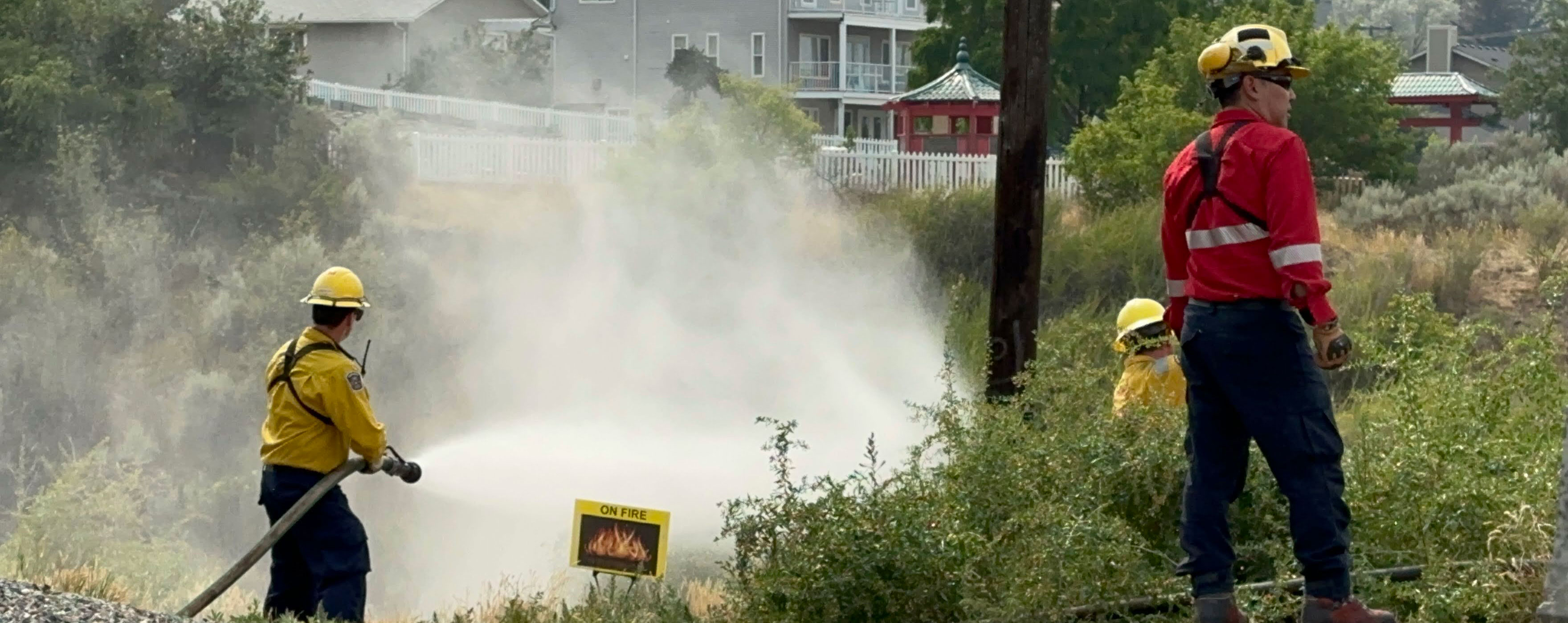 Two firefighters simulating putting out a fire in a training exercise
