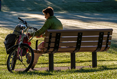 a person sitting on the bench next their bicycle-Memorial Program