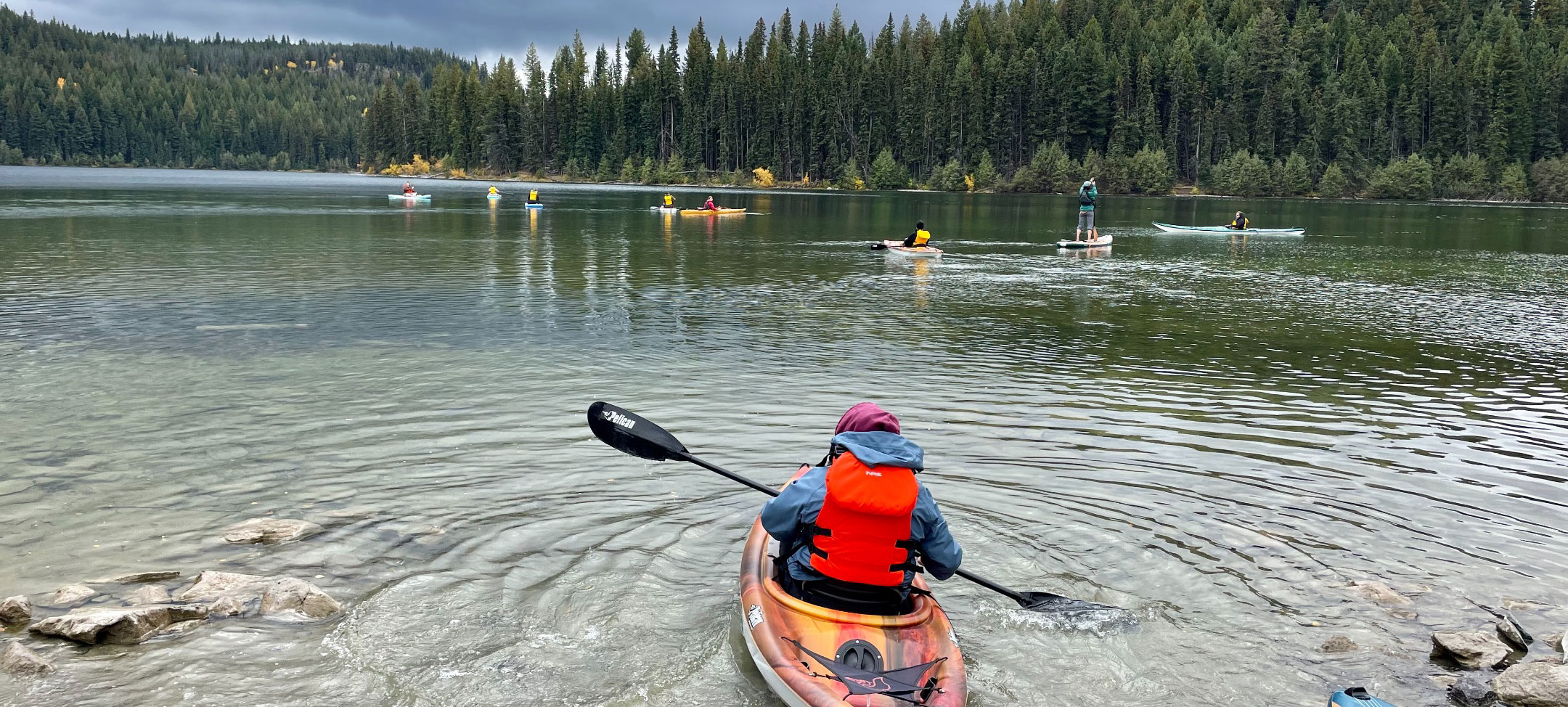 kayaker in a red lifejacket on a lake