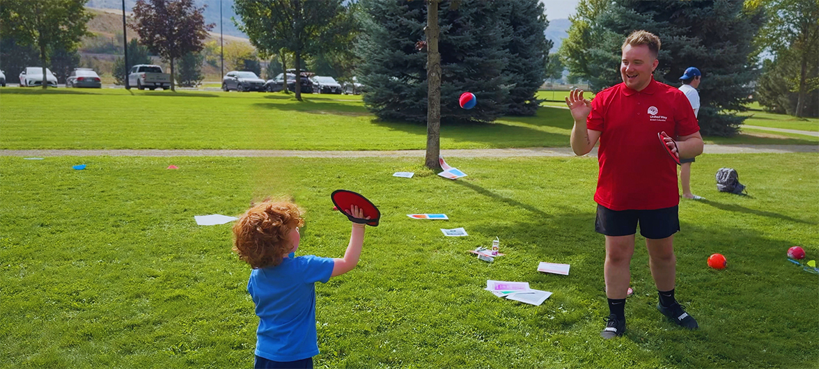 an adult and child playing catch with a velcro ball and mitt