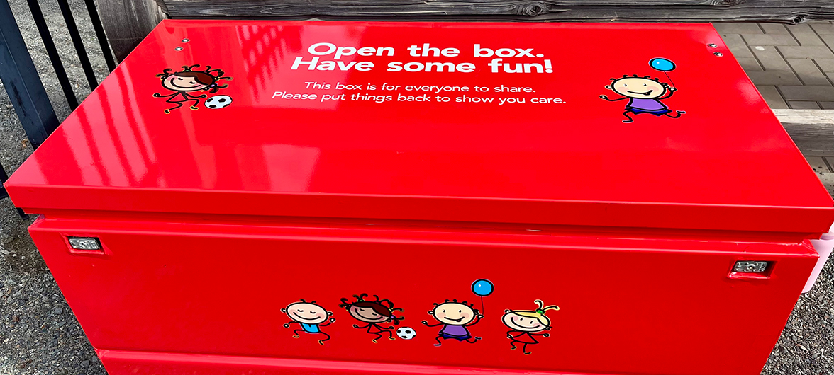 red metal playbox containing toys and games