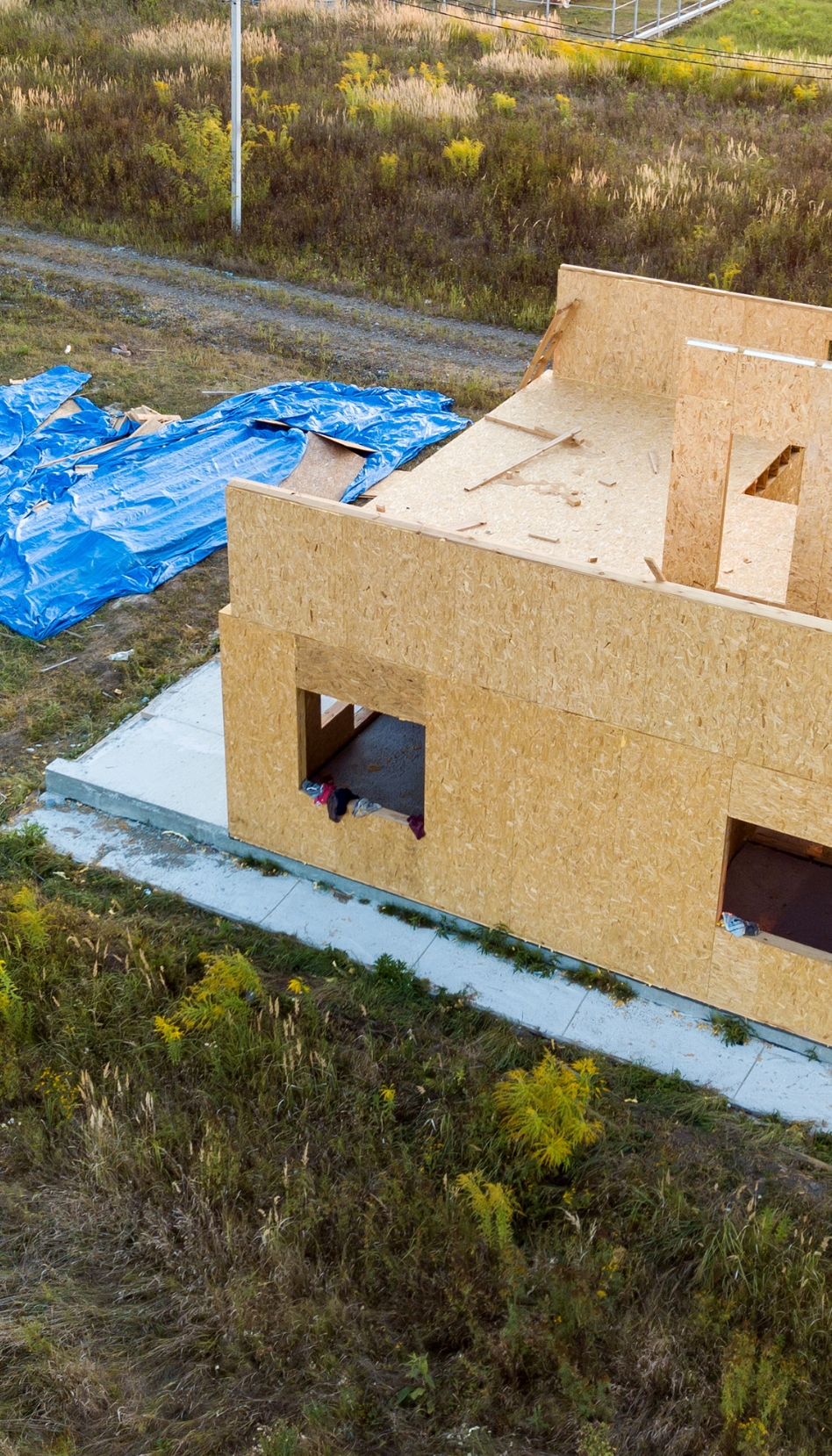 Aerial view of an unfinished single family dwelling under construction.