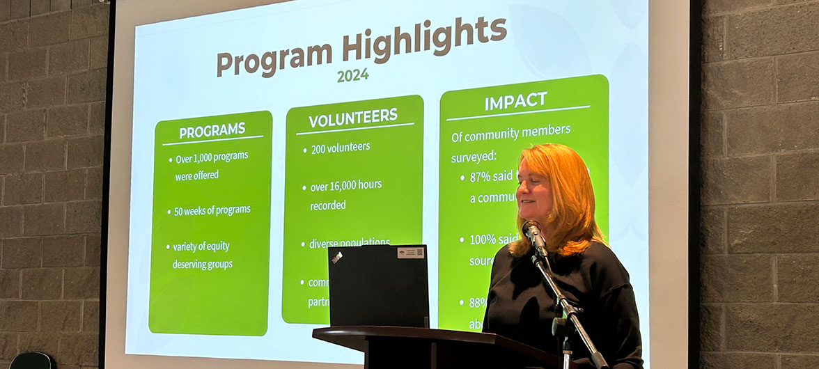 female speaker in front of powerpoint presentation