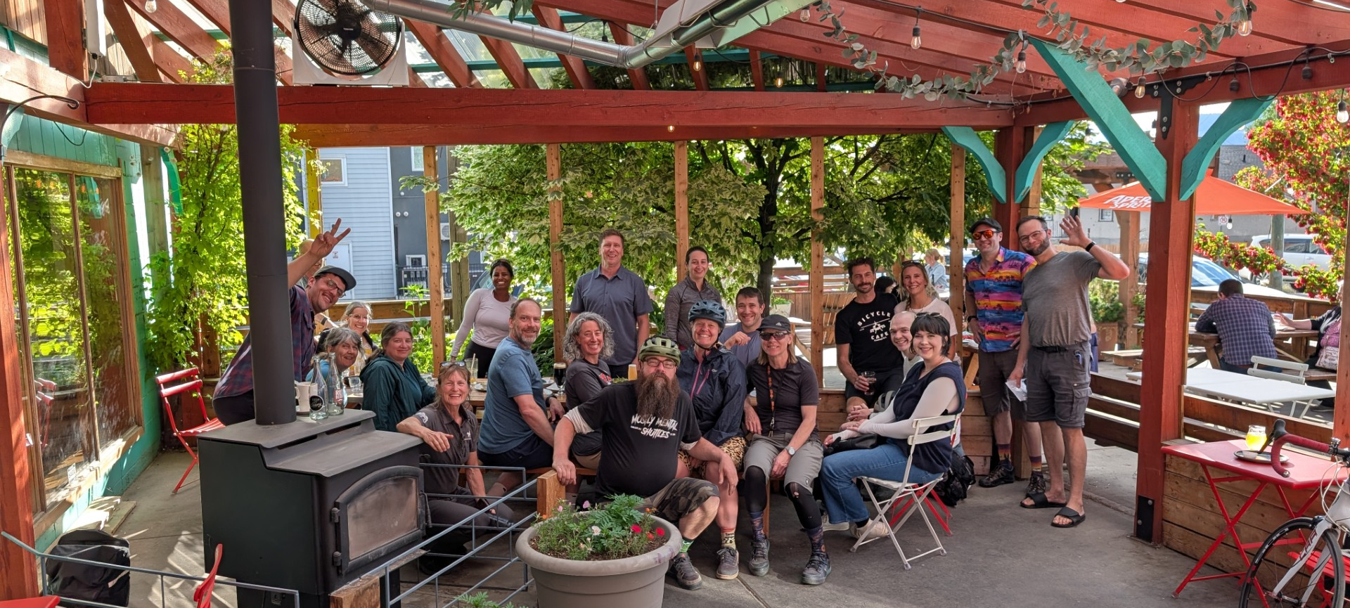A large group of cyclists posing together at the GoByBike after party on the patio at Red Beard Cafe