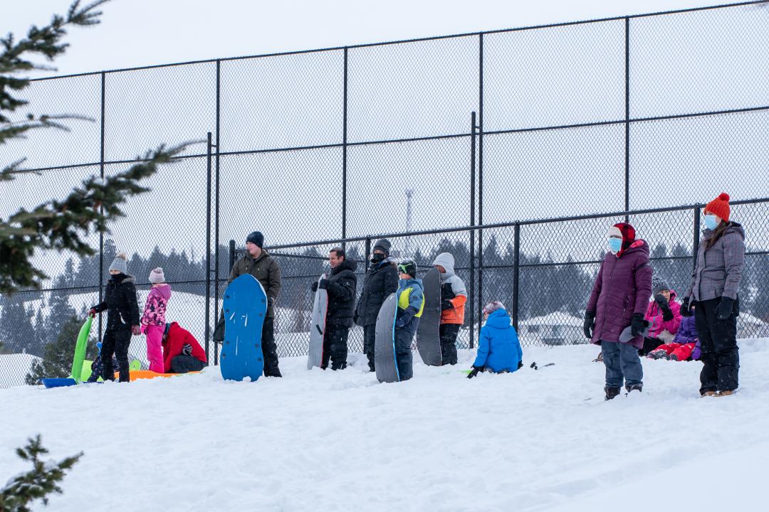 Adults and kids sledding in winter