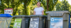 Female EcoSmart team member in front of a waste sorting station