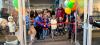 red ribbon being cut with excited children